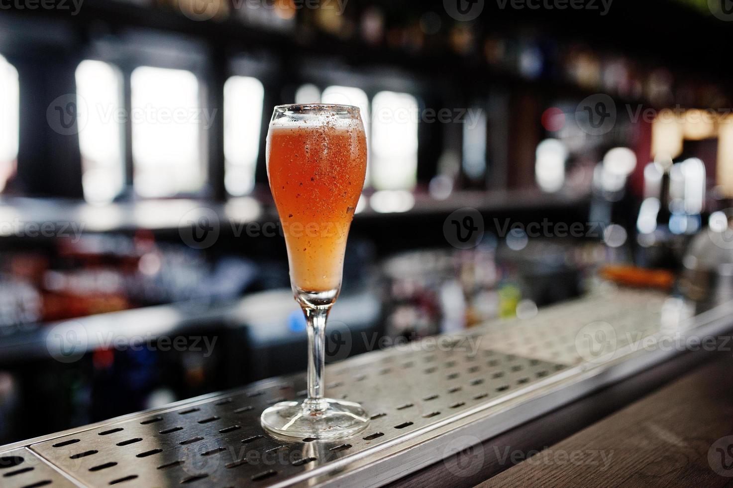 Alcoholic long cocktail with cinnamon at bar table. photo