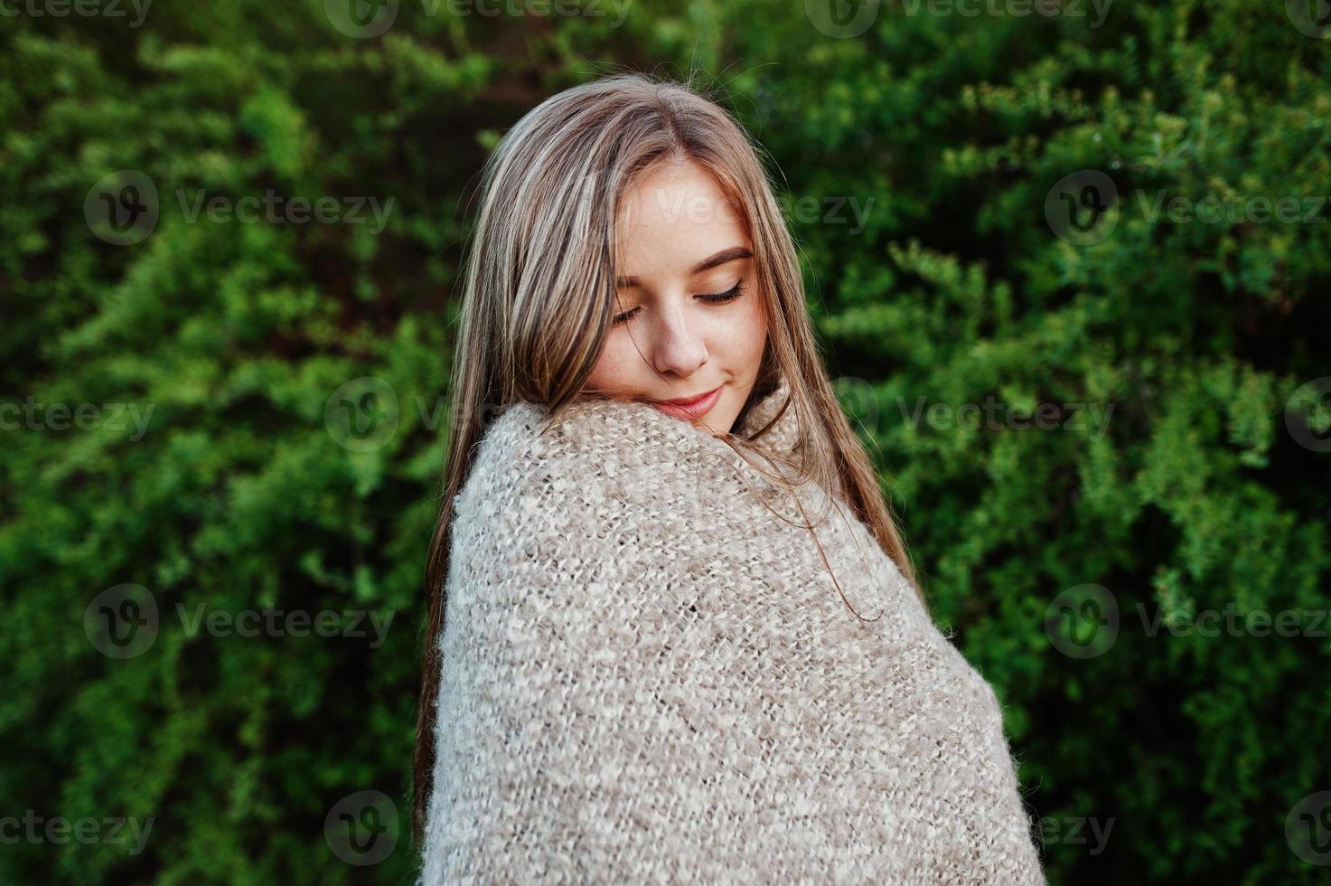 Young brunette girl on plaid having fun at evening spring day. photo