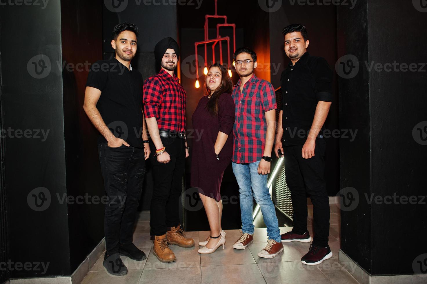 Group of indian friends having fun and rest at night club. photo