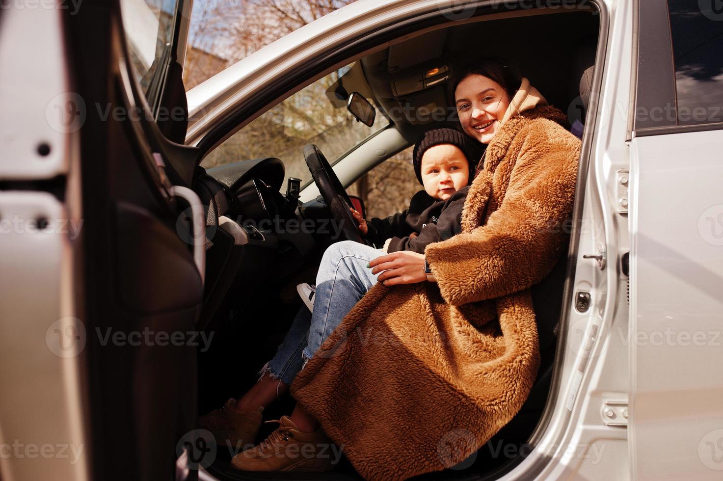 joven madre e hijo en coche. concepto de conducción segura. foto