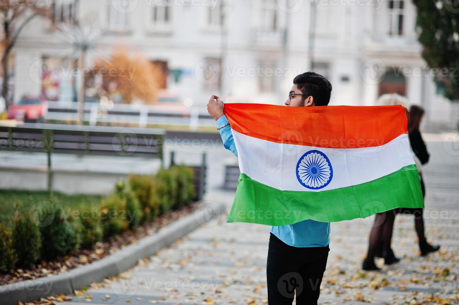 estudiante indio del sur de asia con bandera india posada al aire libre. foto