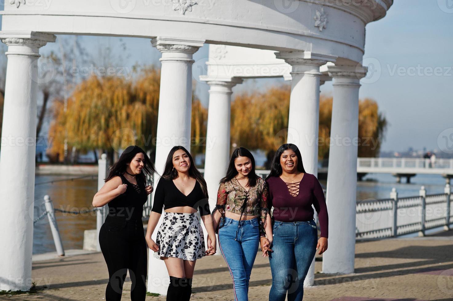 Group of four happy and pretty latino girls from Ecuador posed at street. photo