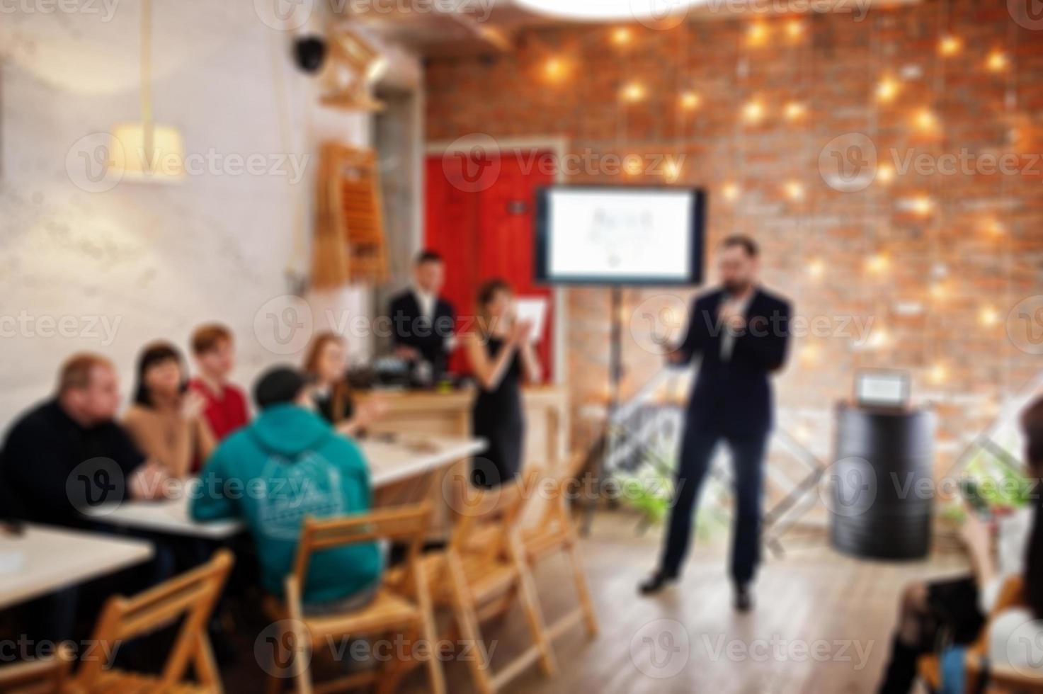 Master class and study concept. Abstract blurred photo of conference or seminar room with speaker on the stage.
