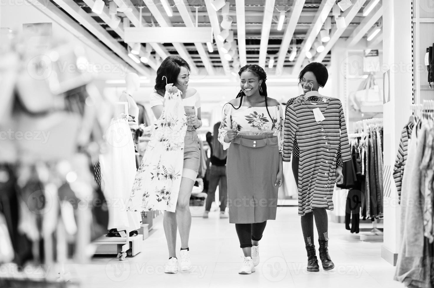 Three african woman choosing clothes at store. Shopping day. photo