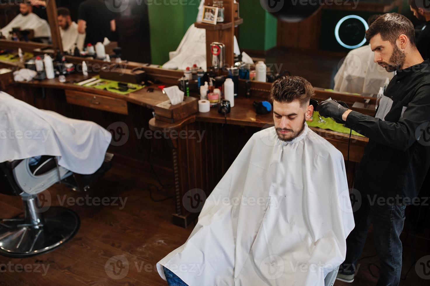 Handsome bearded man at the barbershop, barber at work. photo