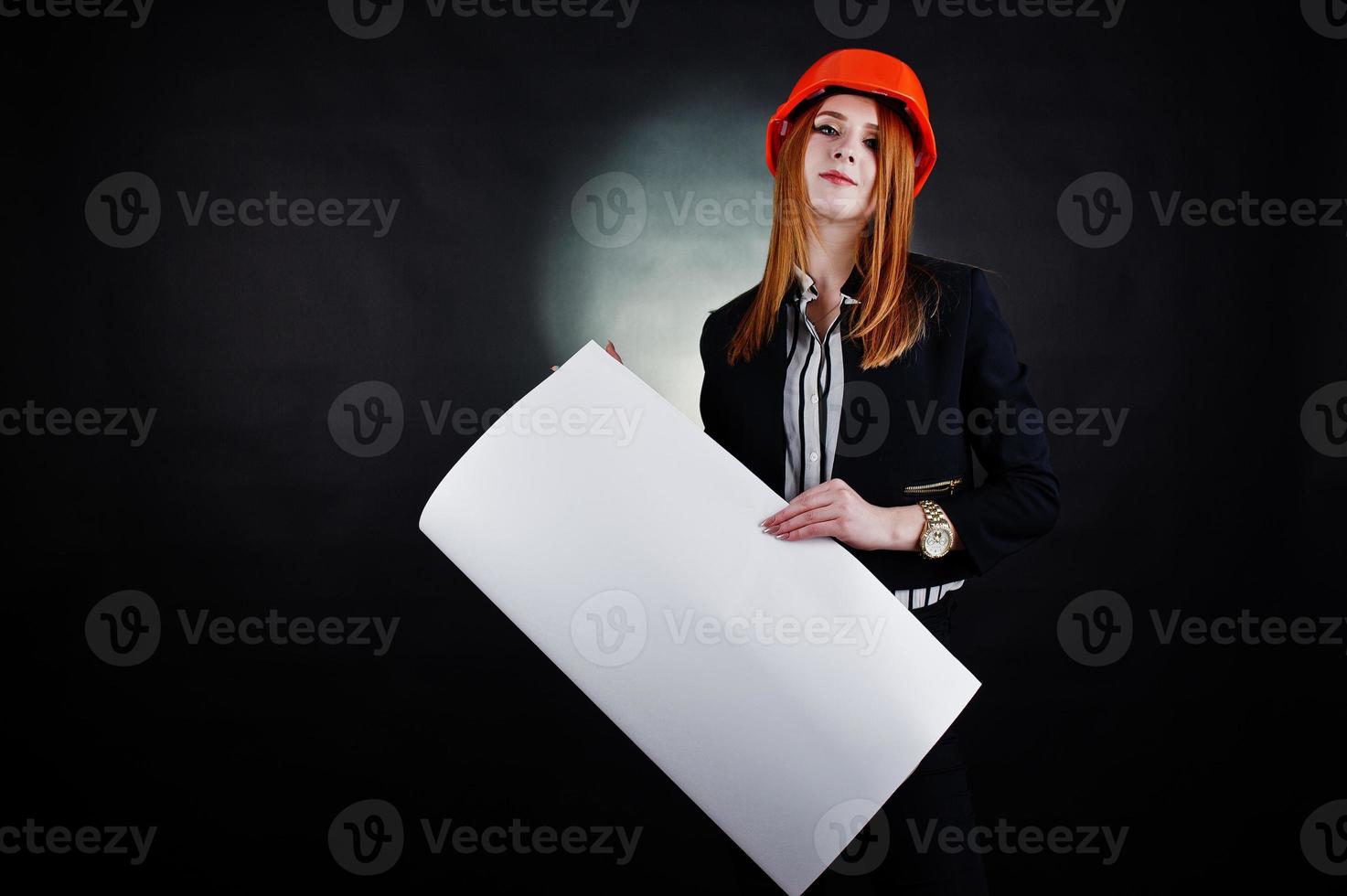 Engineer woman in orange protect helmet with construction paper projekt. photo