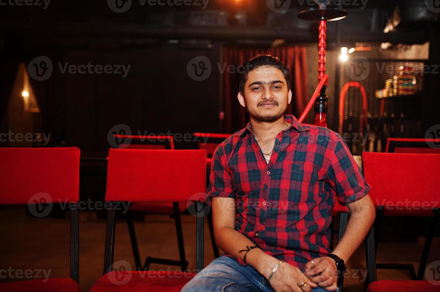 Asian man smoke hookah and having rest at lounge bar. photo