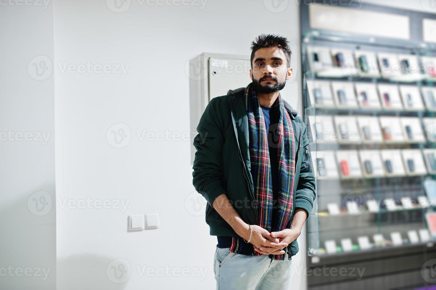 Indian beard man customer buyer in jacket at mobile phone store. South asian peoples and technologies concept. Cellphone shop. photo