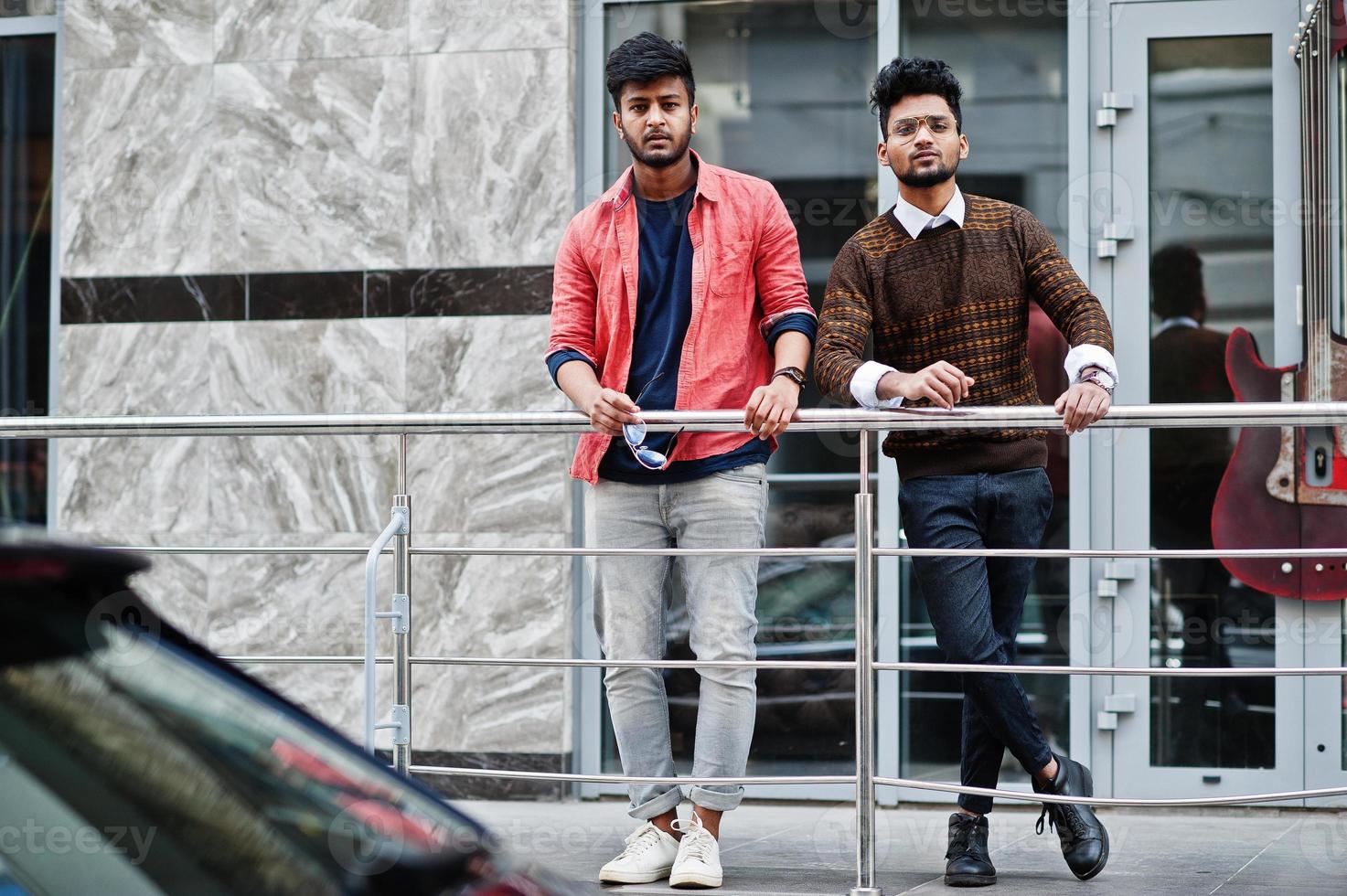 Dos jóvenes y elegantes modelos de fritos indios posando en la calle. foto