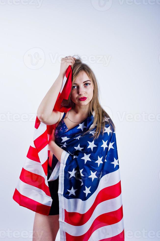 linda chica en sujetador y pantalones cortos con bandera americana de estados unidos aislada sobre fondo blanco. foto