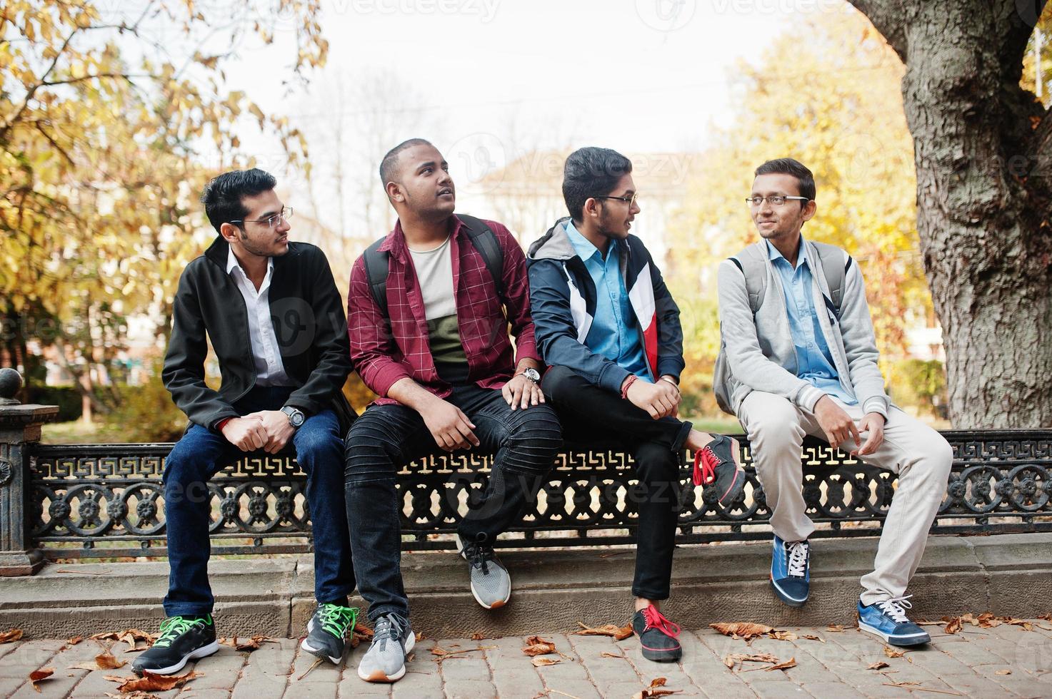Group of four indian teen male students. Classmates spend time together