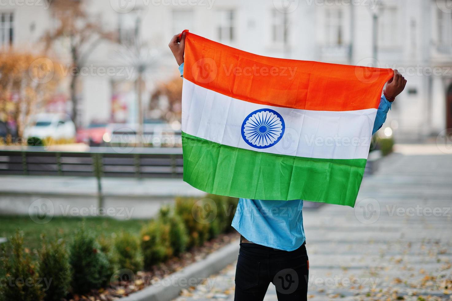estudiante indio del sur de asia con bandera india posada al aire libre. foto