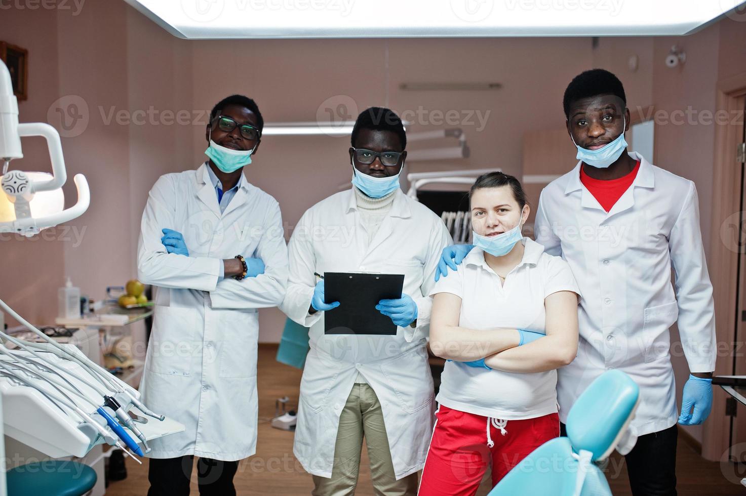 equipo multirracial de médicos dentistas. tres médicos afroamericanos con una doctora caucásica. foto