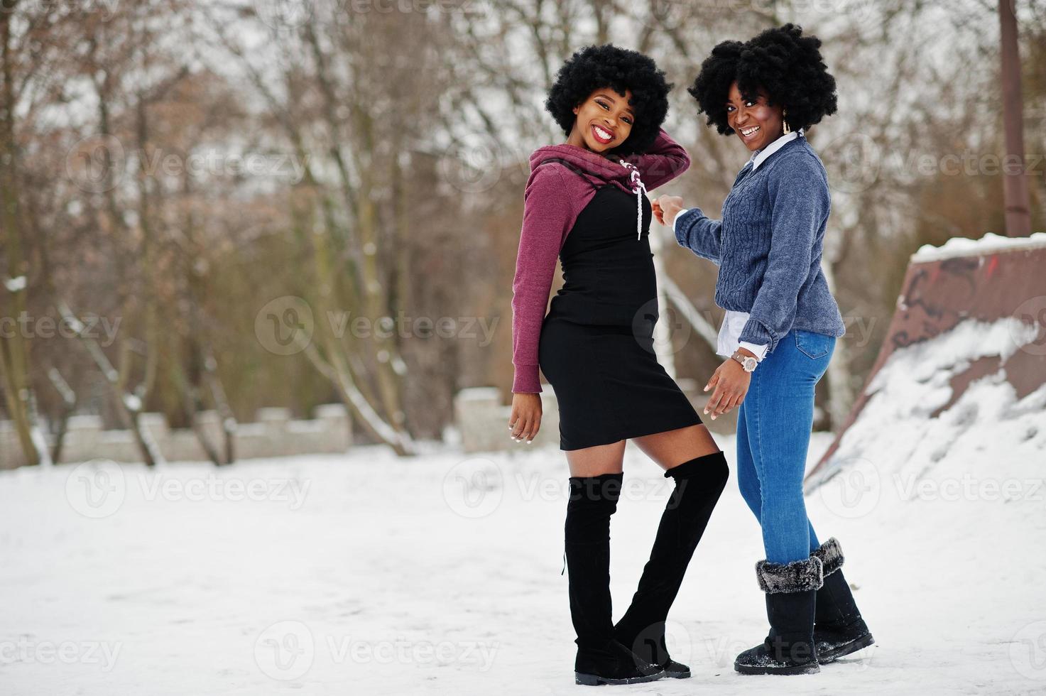 Two curly hair african american woman wear on sweaters posed at winter day. photo
