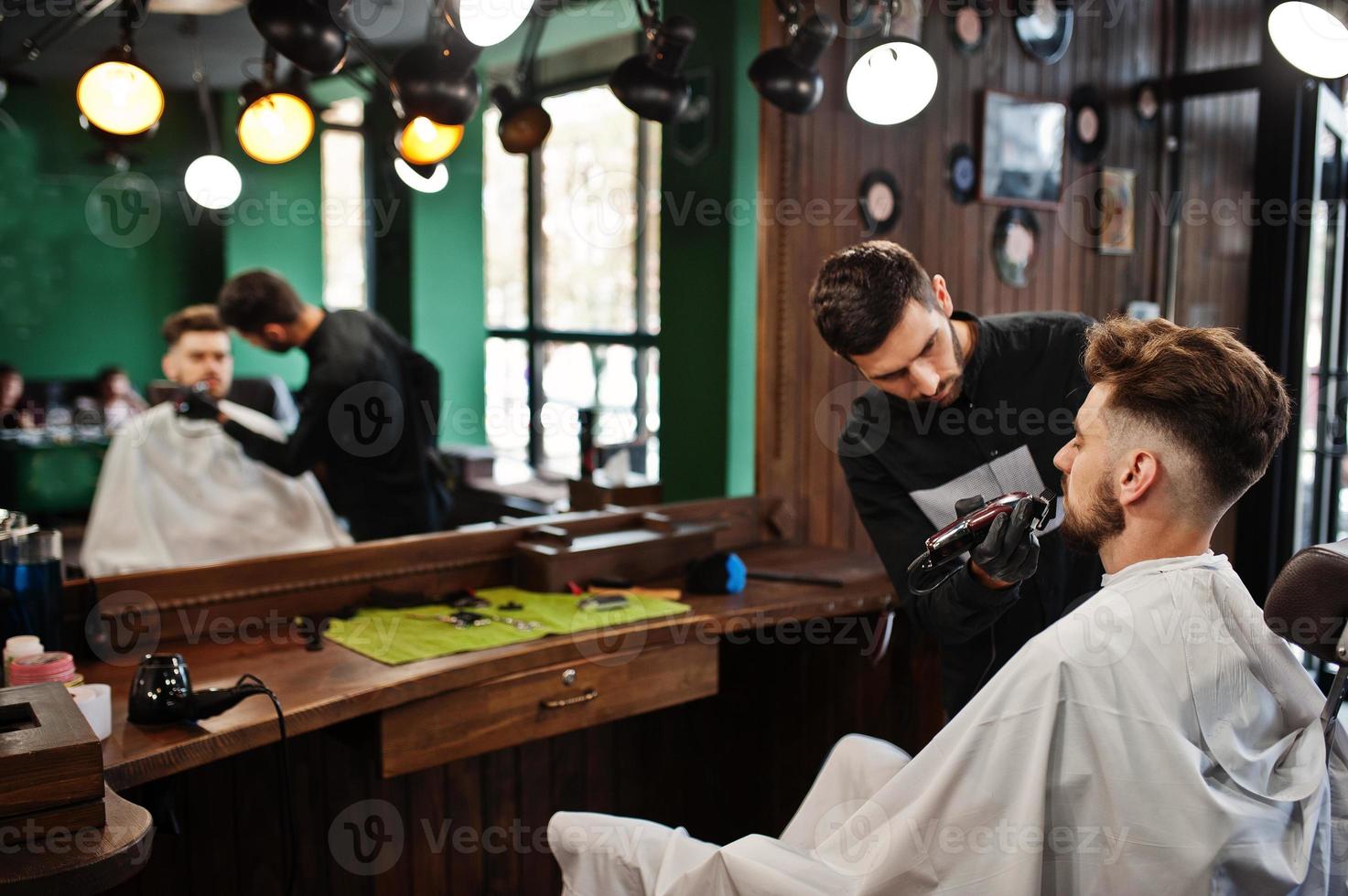 apuesto hombre barbudo en la barbería, peluquero en el trabajo. foto