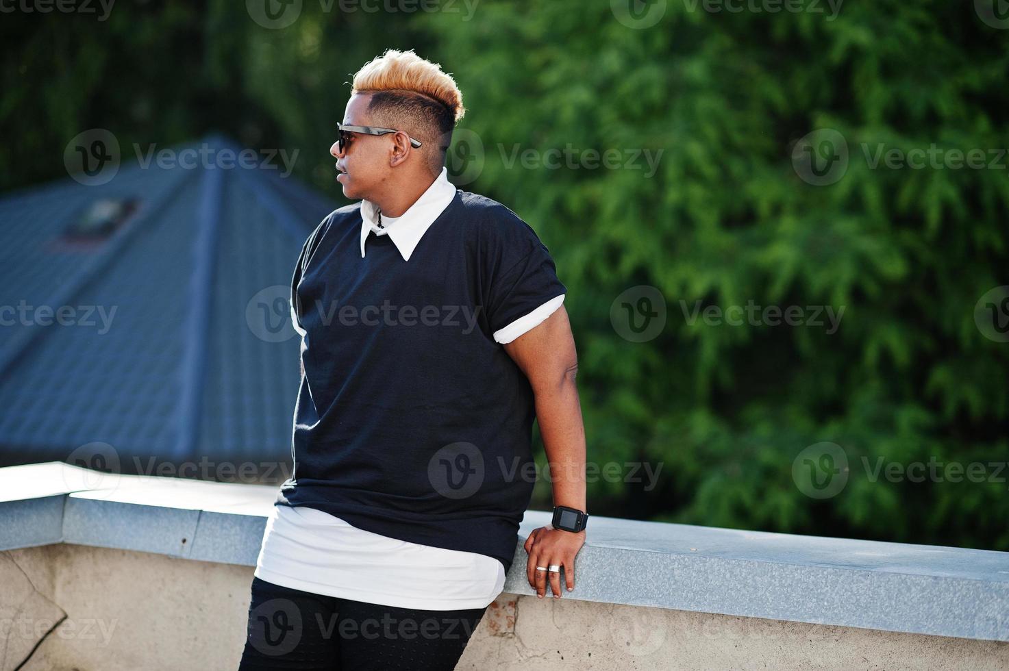 Stylish arabian muslim boy with originally hair and sunglasses posed on streets at roof. photo