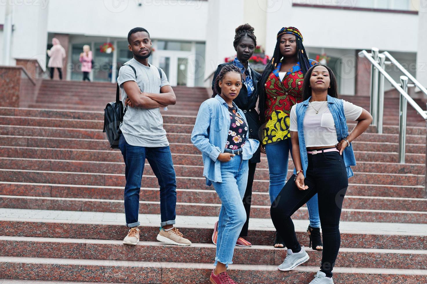 grupo de cinco estudiantes universitarios africanos que pasan tiempo juntos en el campus en el patio de la universidad. amigos negros afro estudiando. tema de la educación foto