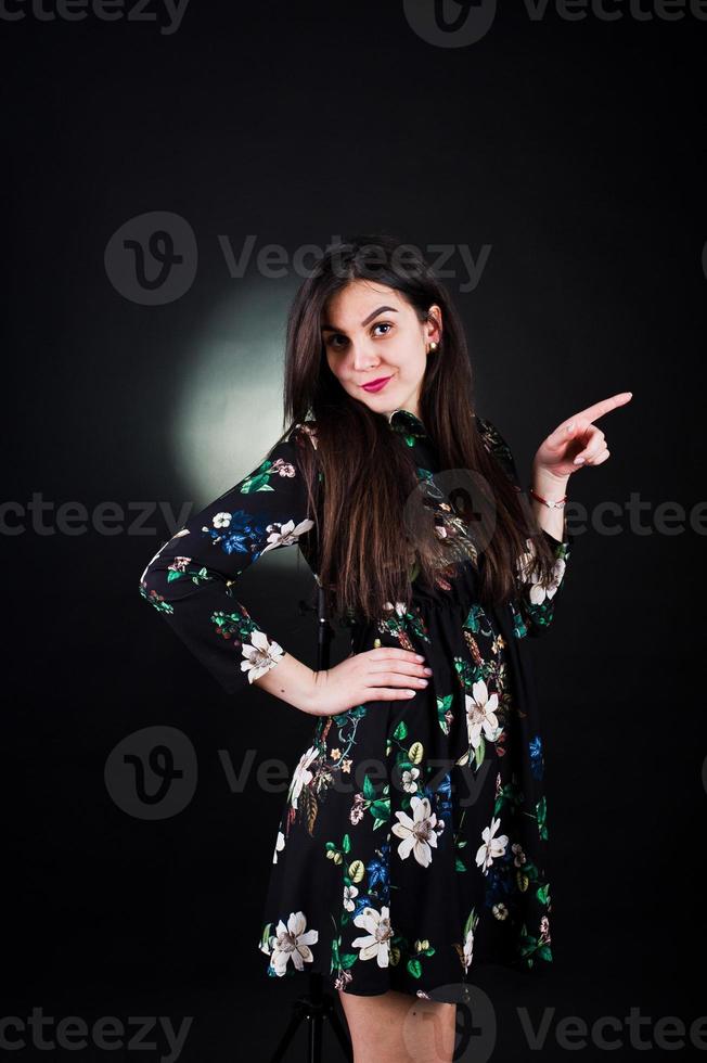 Portrait of a fabulous young woman in floral dress in the dark studio. photo