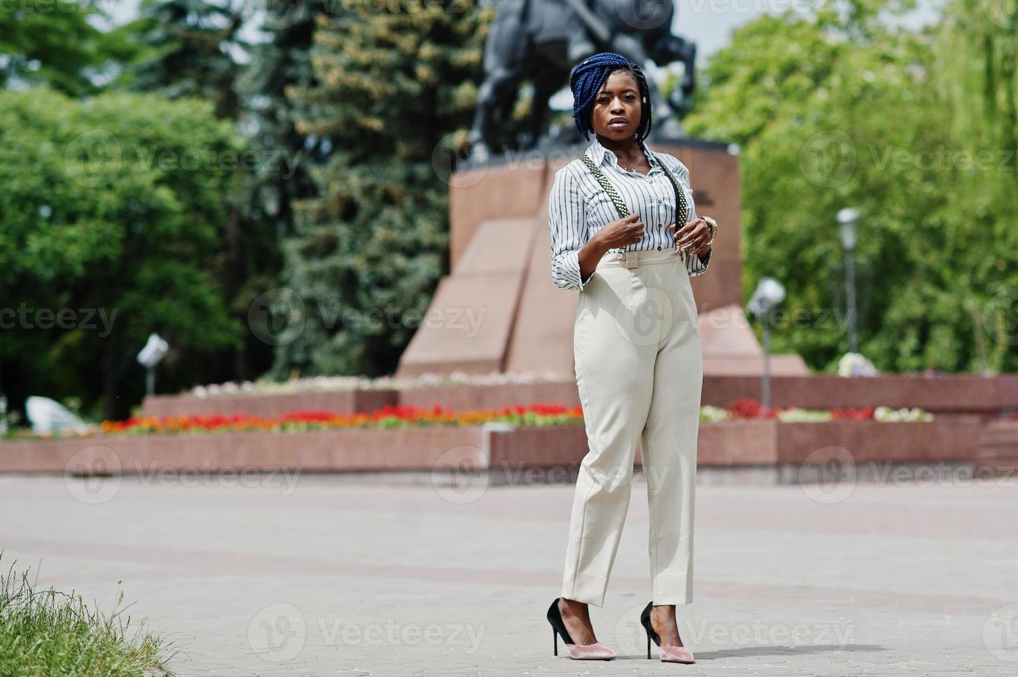 Stylish african american business woman at trousers with suspender and blouse posed outdoor. photo