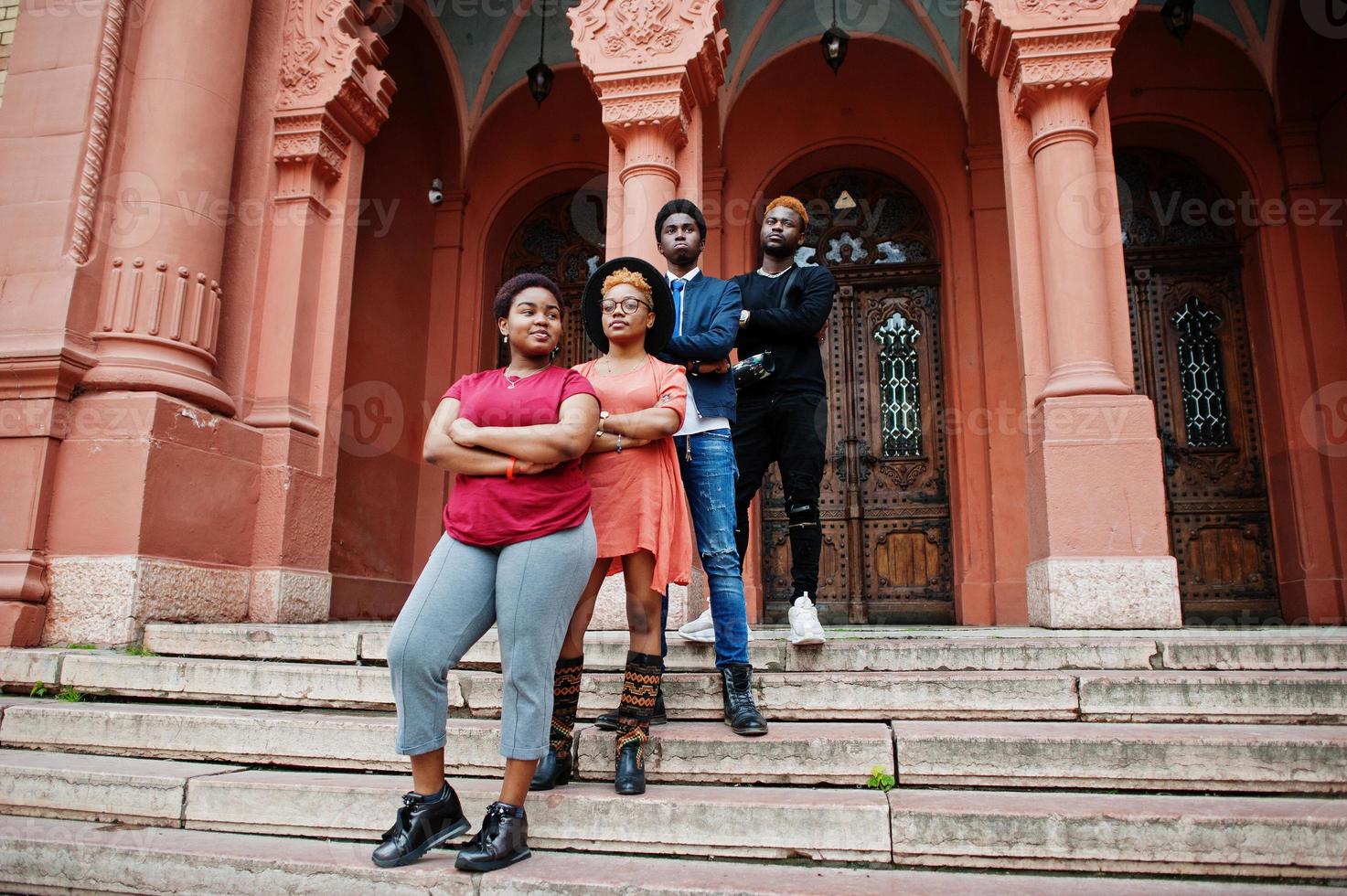 Four african friends posed outdoors against old architecture. Two black girls with guys. photo