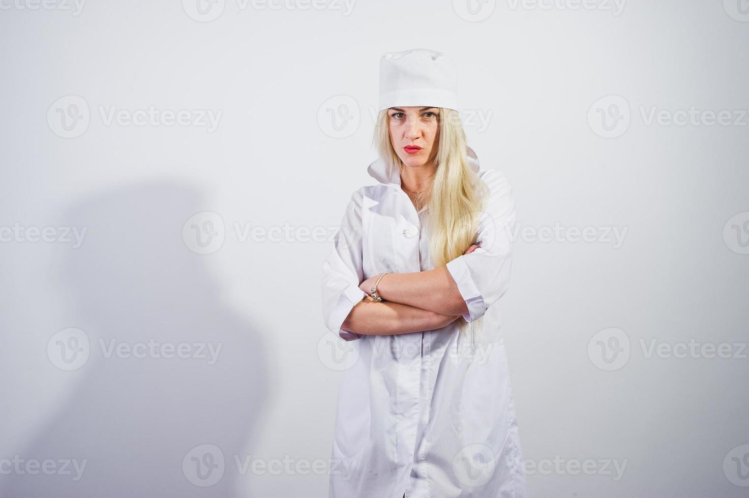 atractiva rubia doctora o enfermera en bata de laboratorio aislada en fondo blanco. foto