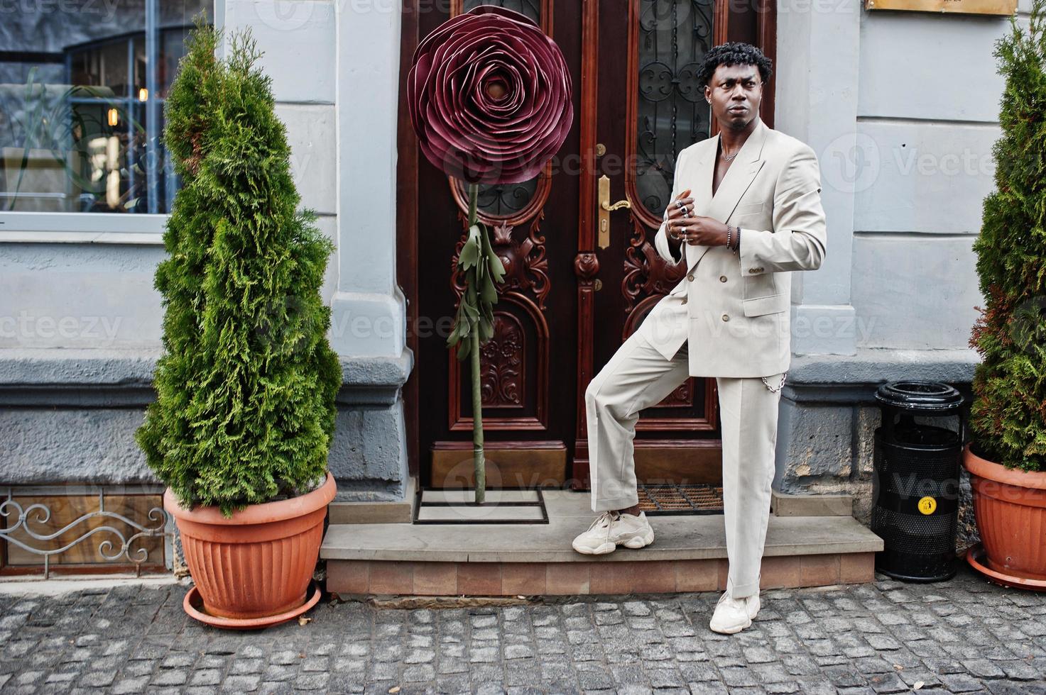 hombre afro con estilo en traje beige de la vieja escuela. joven africano de moda con chaqueta informal en el torso desnudo. foto