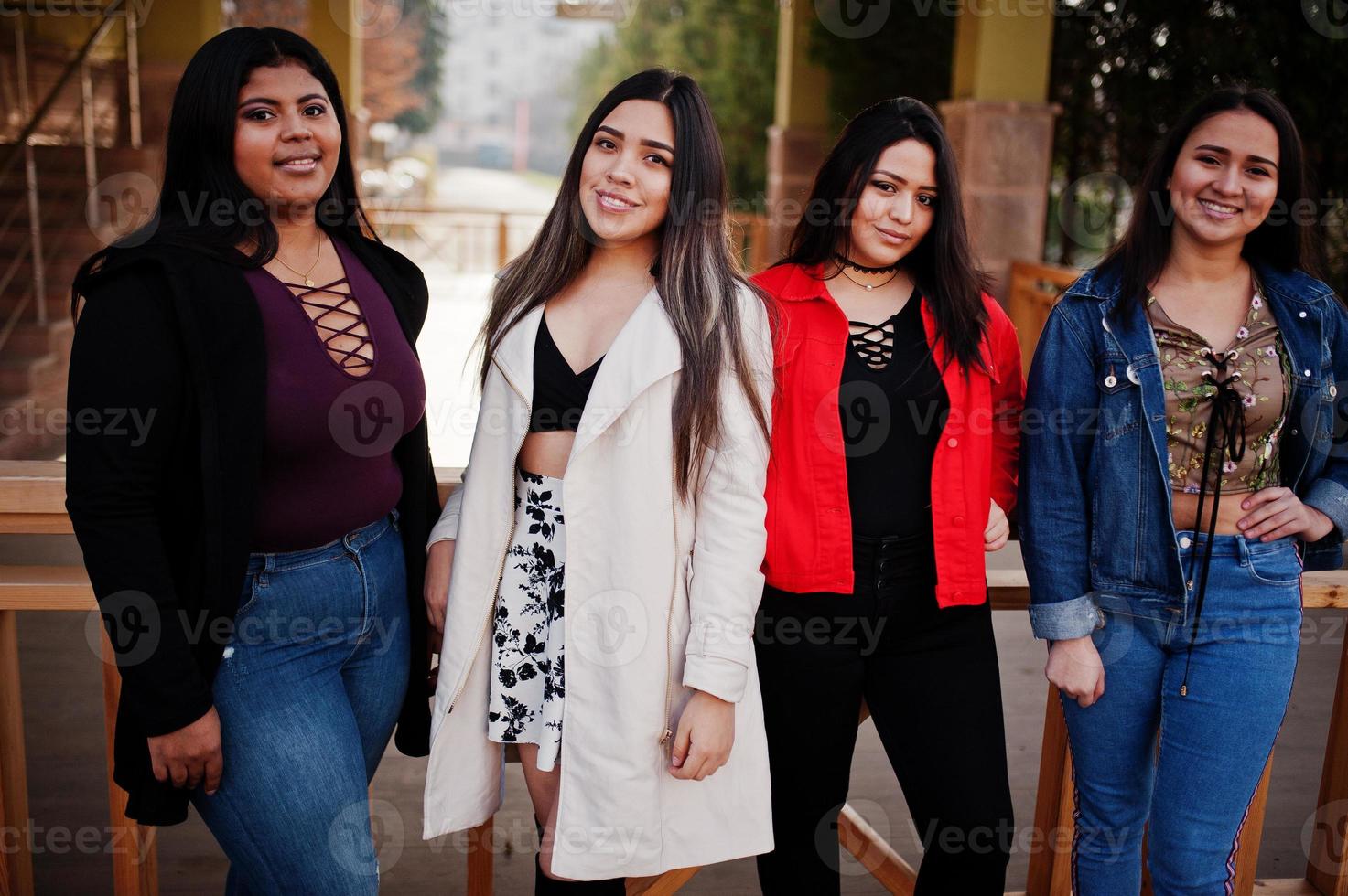 Group of four happy and pretty latino girls from Ecuador posed at street. photo