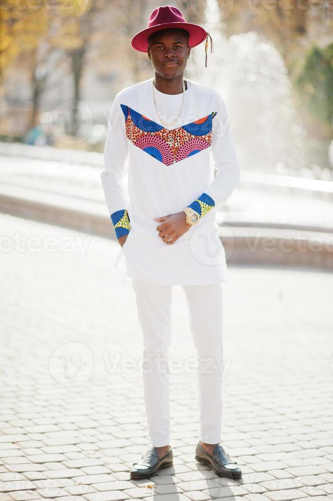 elegante hombre afro francés de moda con sombrero rojo y blanco posado en día de otoño. chico modelo africano negro contra fuente. 10502006 de stock en Vecteezy