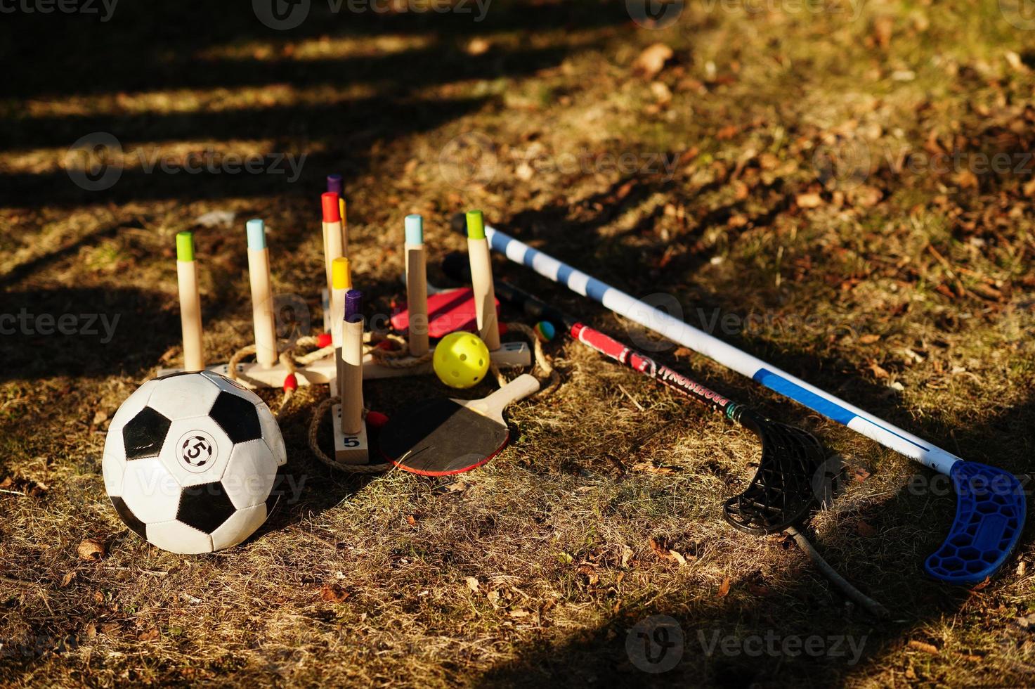 Kids play set on grass. Wooden ring toss, ball,  floorball, ping pong racket. photo