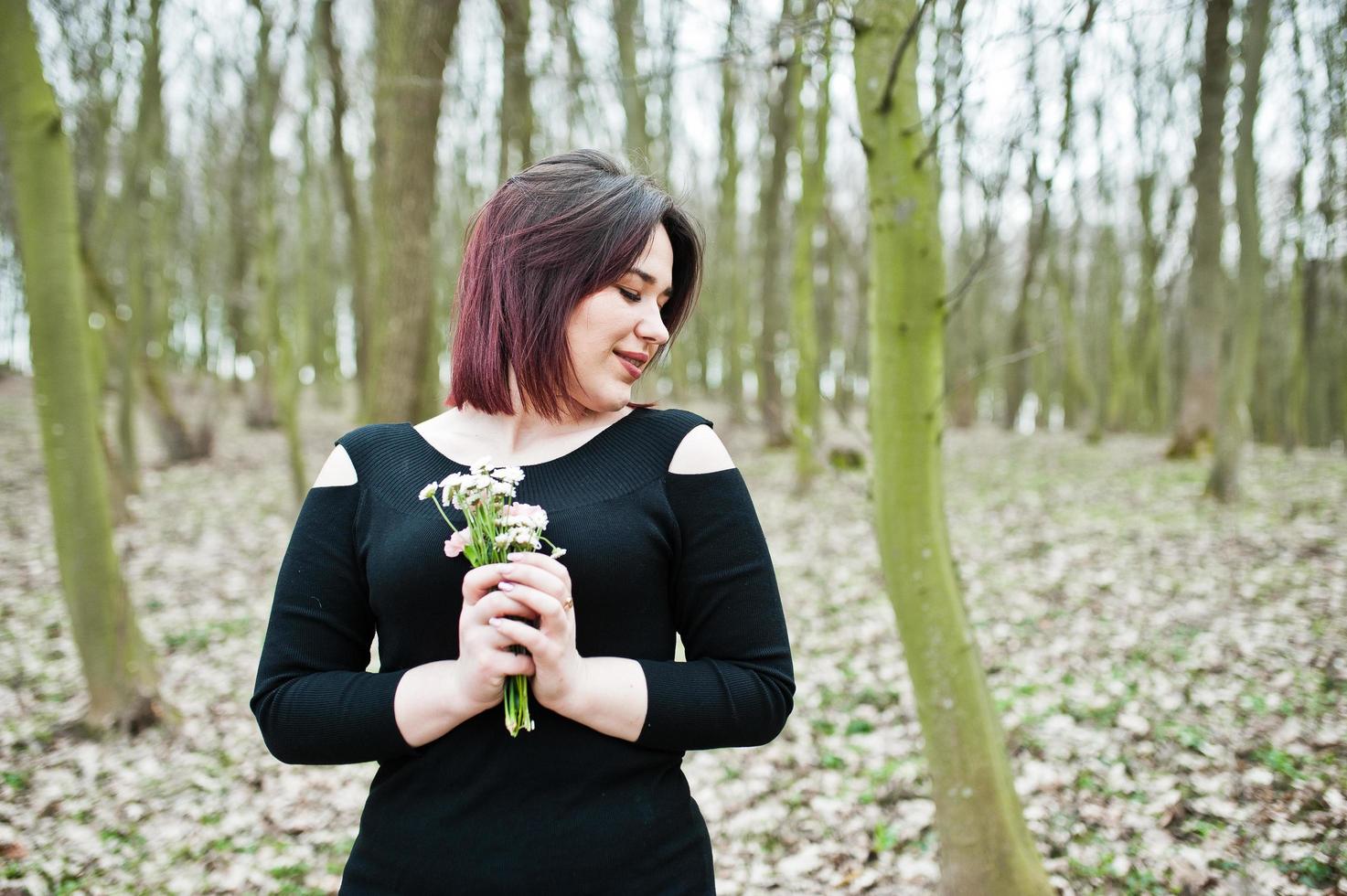 Portrait of brunette girl in black dress at spring wood. photo