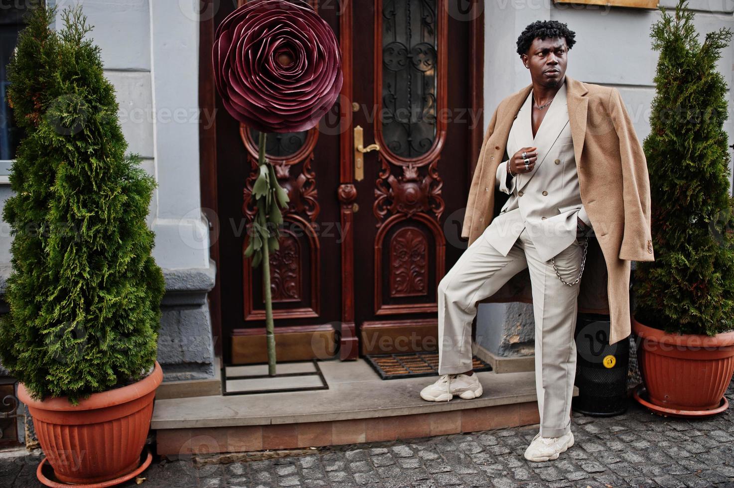 Stylish afro man in beige old school suit and coat. Fashionable young African male in casual jacket on bare torso. photo