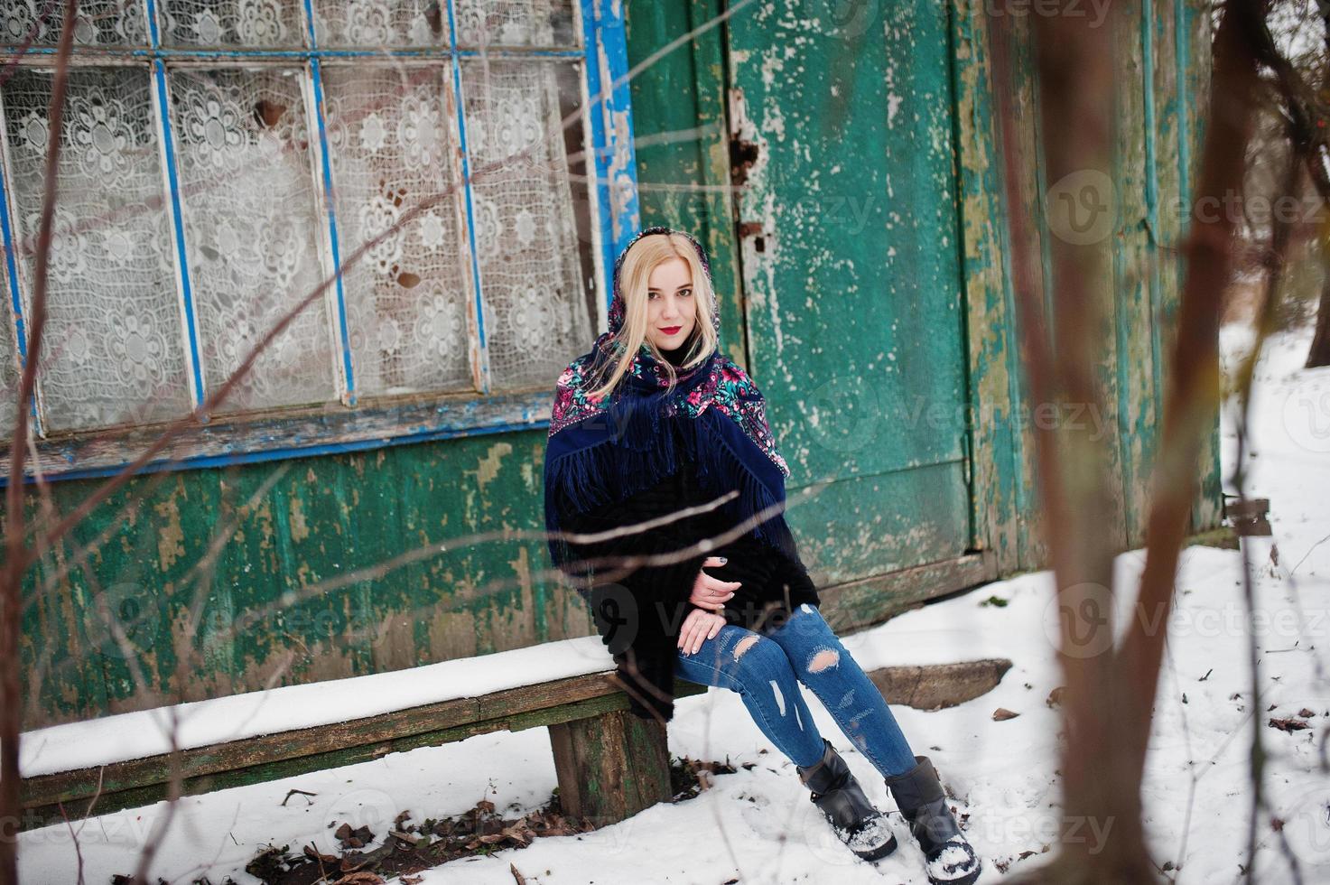 chica rubia con bufanda bordada a mano posada en el día de invierno. pañuelo de mujer. foto