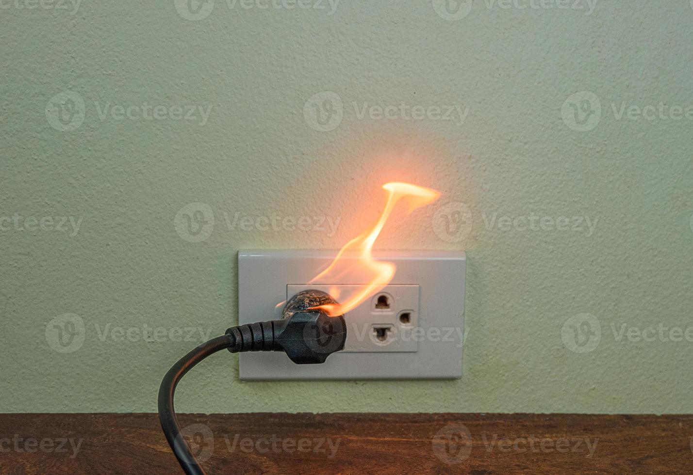 en la pared del receptáculo del enchufe del cable eléctrico del fuego foto