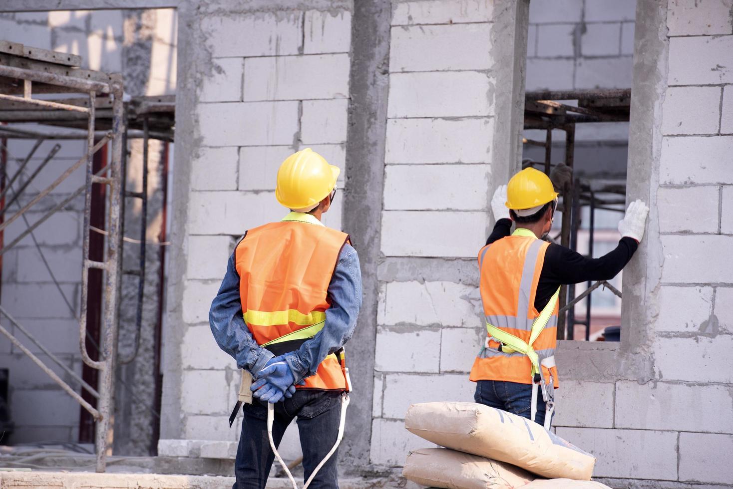 El albañil de ladrillo ligero está hecho de arcilla expandida. elementos en la construcción de mampostería el constructor sostiene los ladrillos un hombre que lleva un casco en un sitio de construcción foto