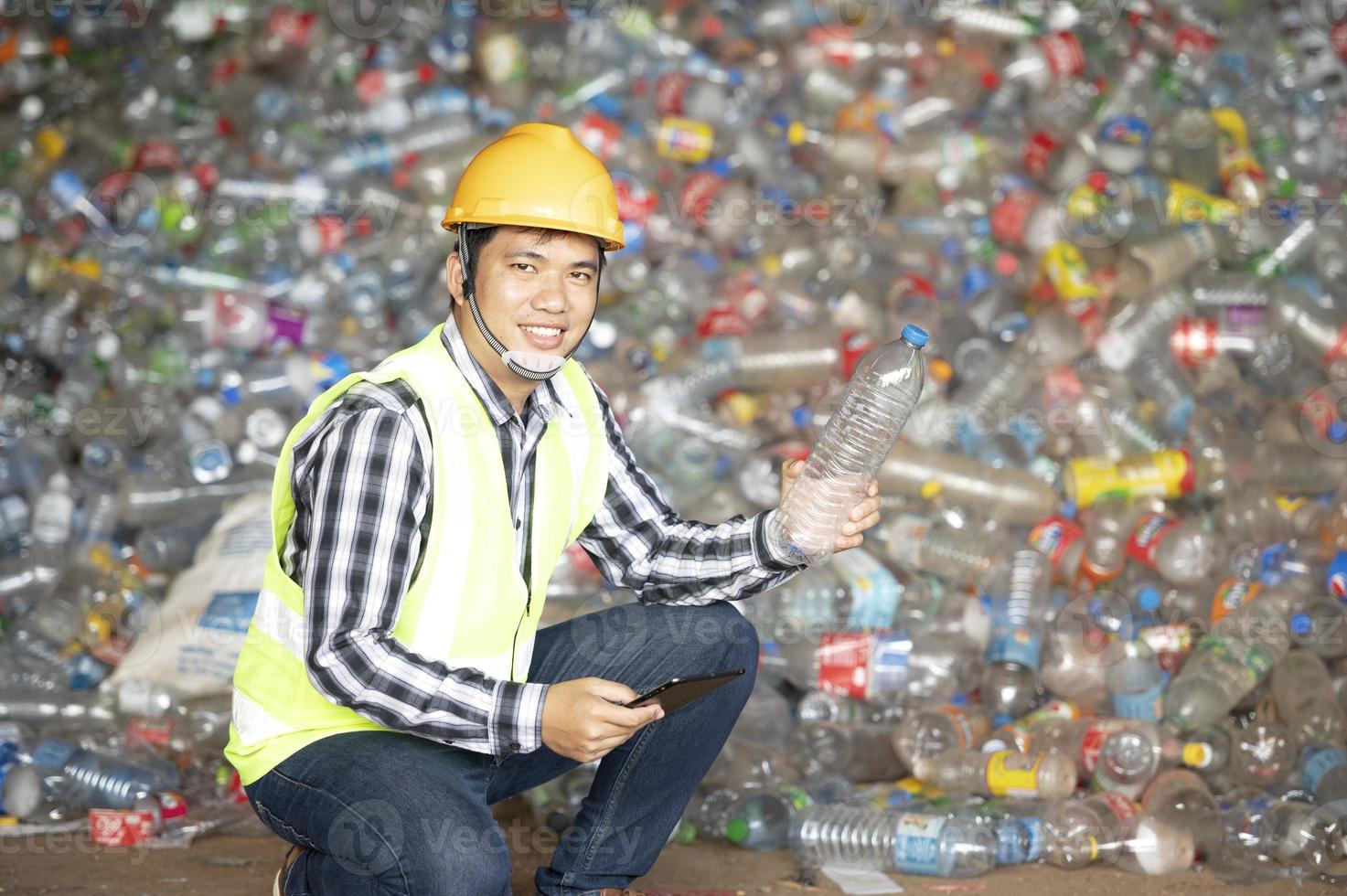 A worker controls the recycling of a recycling plant. Plastic bottles and plastic waste photo