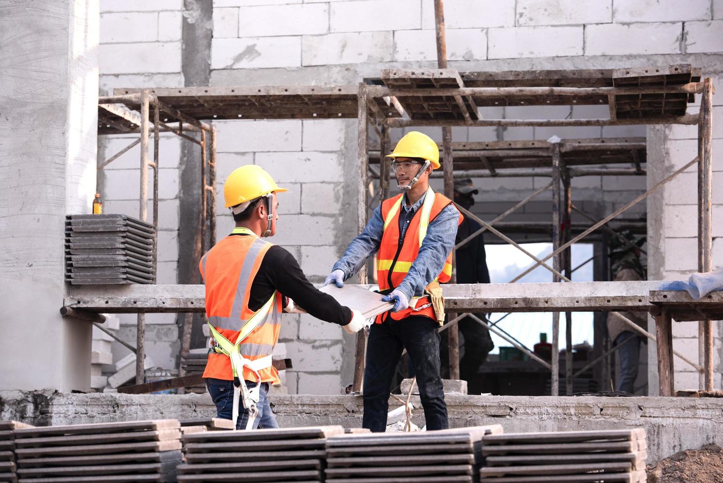 El albañil de ladrillo ligero está hecho de arcilla expandida. elementos en la construcción de mampostería el constructor sostiene los ladrillos un hombre que lleva un casco en un sitio de construcción foto