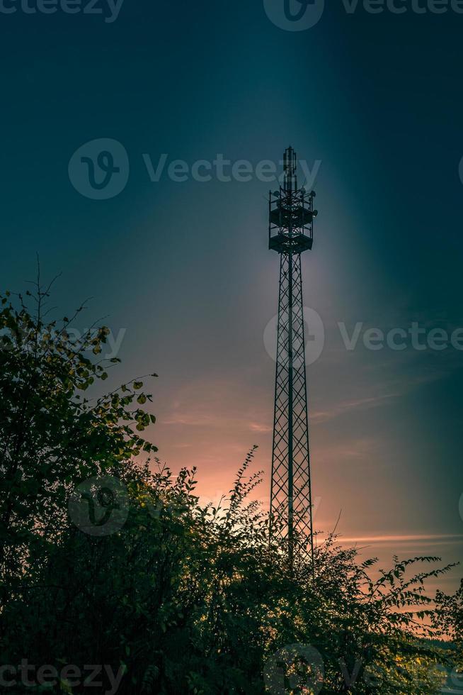 Tall steel mast silhouetted against a pink sunset photo