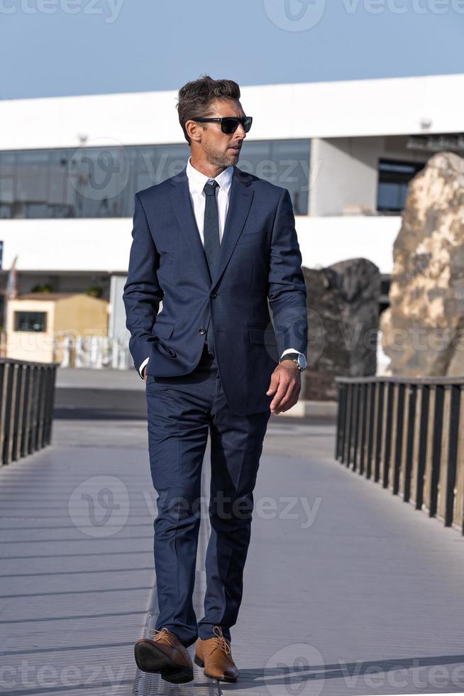 Confident businessman walking on bridge photo