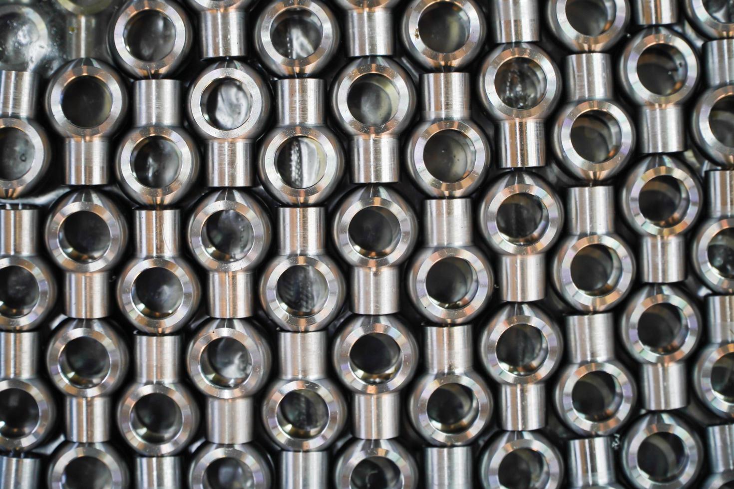 Shiny steel parts background. Regular industrial metal production pattern with selective focus.High precision steel automotive parts manufacturing by innovative CNC machining photo