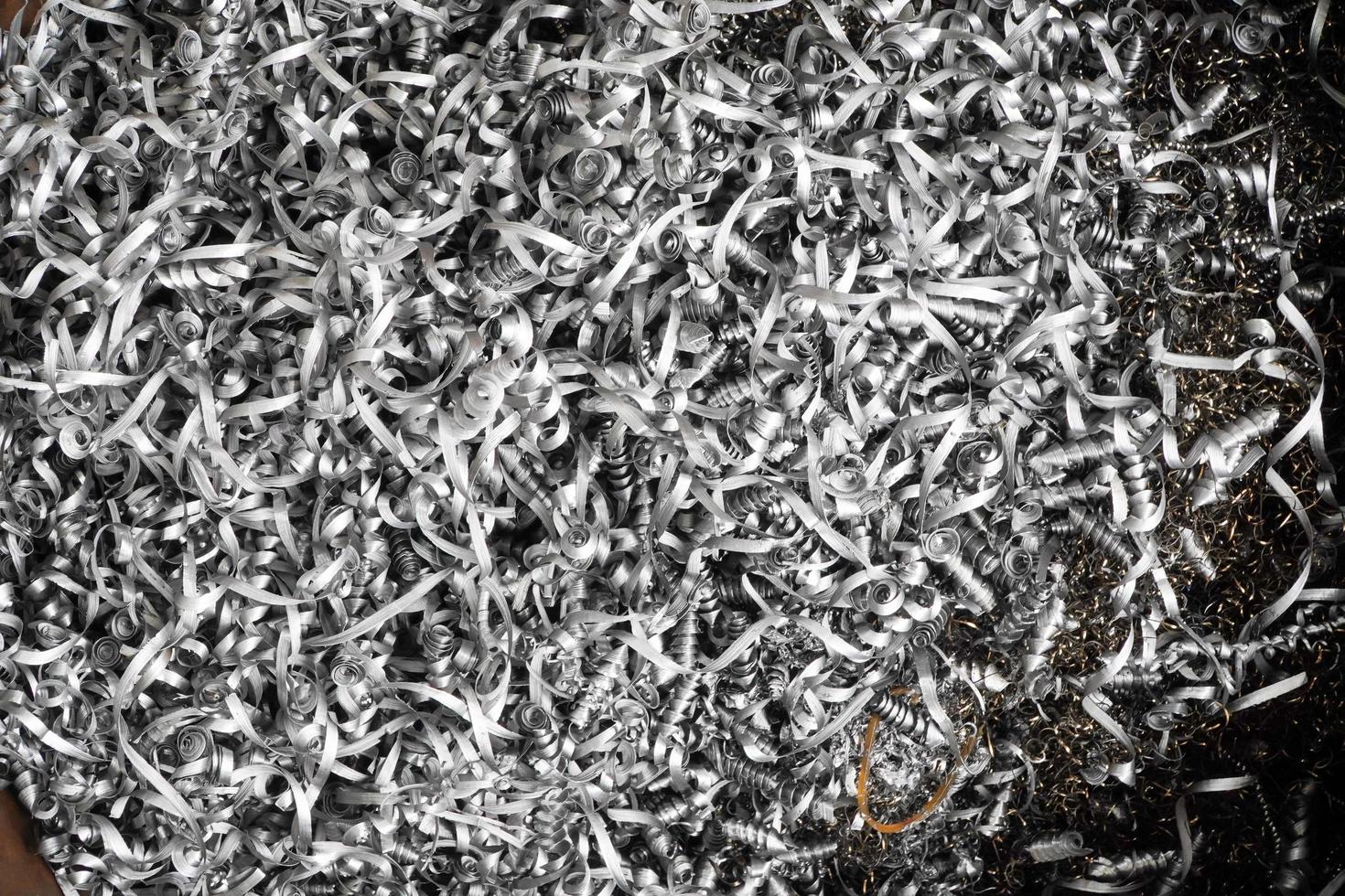 steel scrap materials recycling. aluminum chip waste after machining metal parts on a cnc lathe. closeup twisted spiral steel shavings. small roughness sharpness. photo