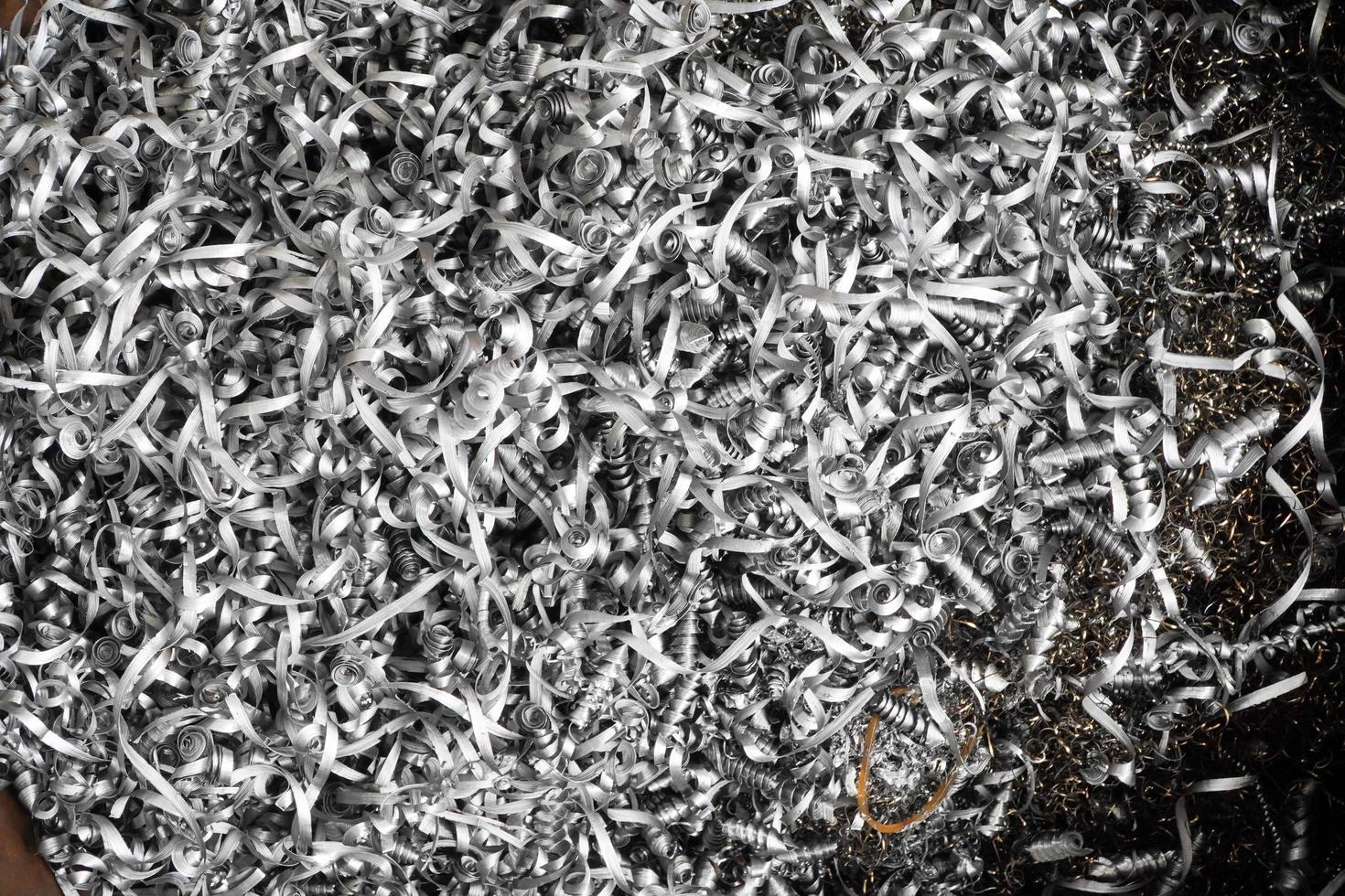steel scrap materials recycling. aluminum chip waste after machining metal parts on a cnc lathe. closeup twisted spiral steel shavings. small roughness sharpness. photo