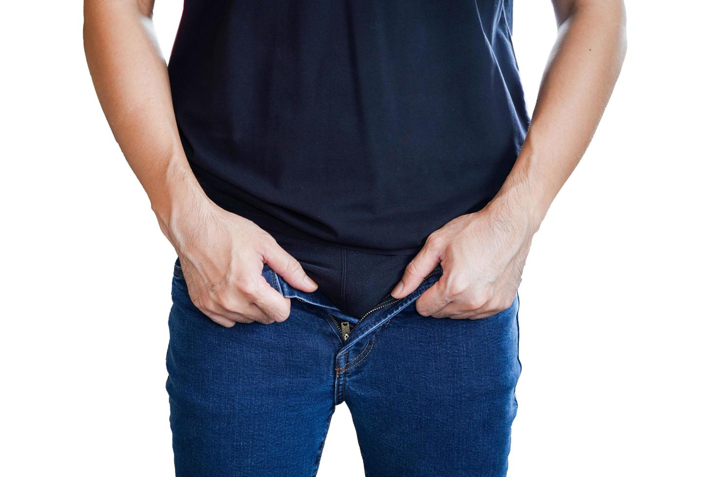 Young man buttoning up jeans on white background,obesity, saggy belly, plus size photo