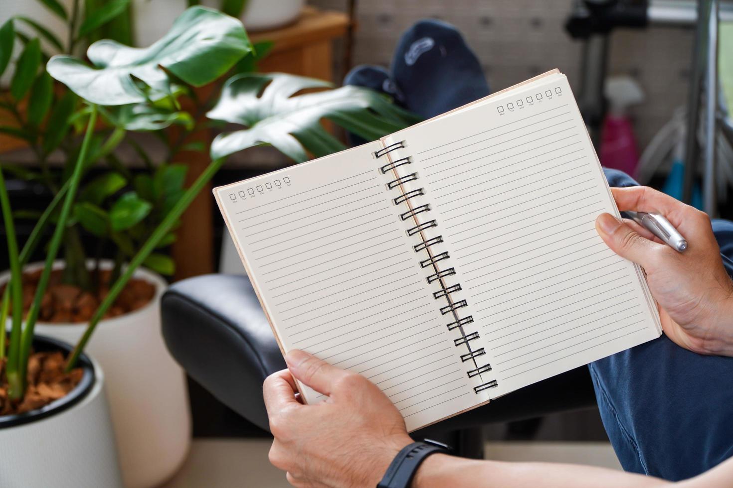 man sitting and resting using a pen to write a notebook.Business and education concept. photo