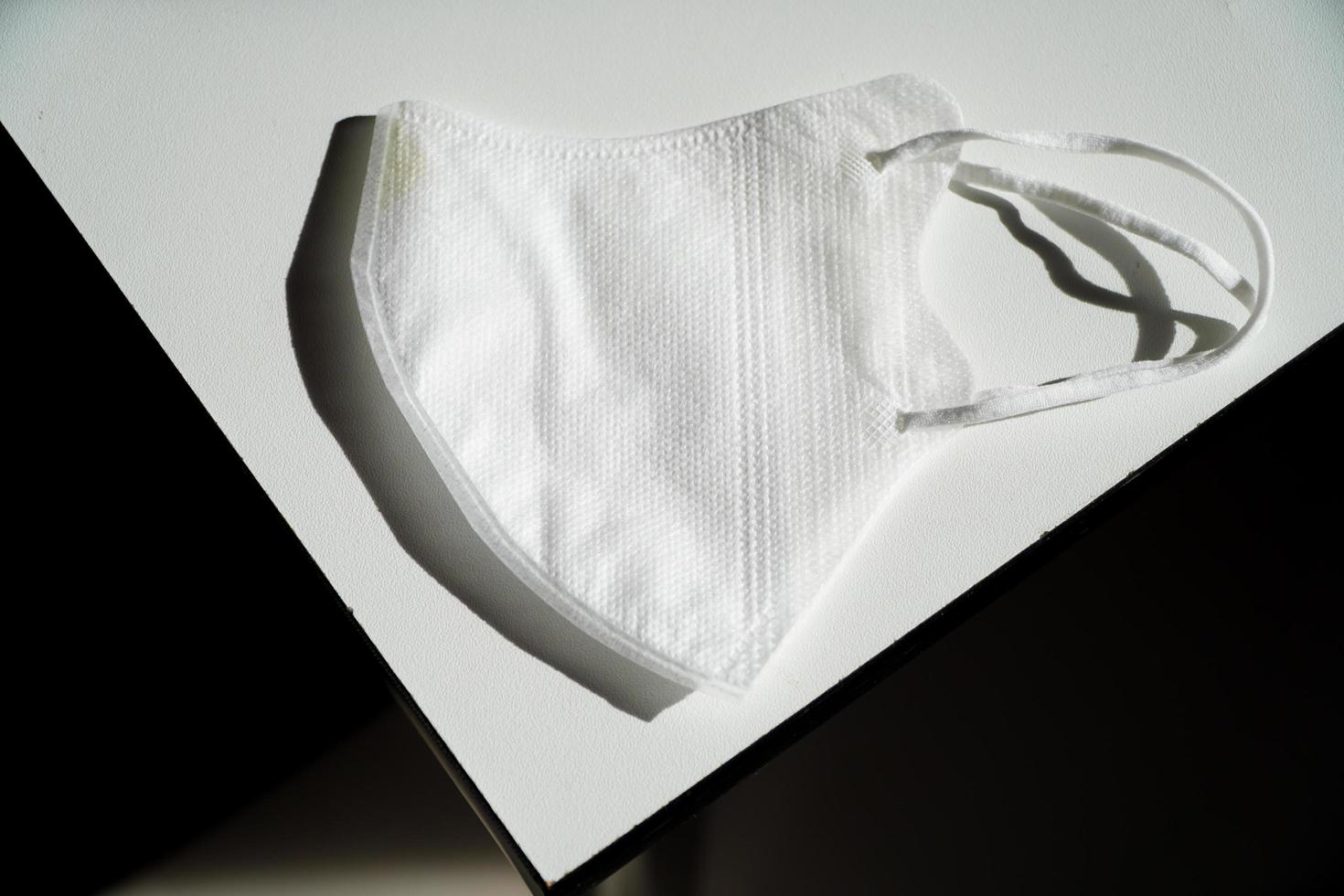White Medical Mask On White Table,White disposable medical face mask on gray background. photo