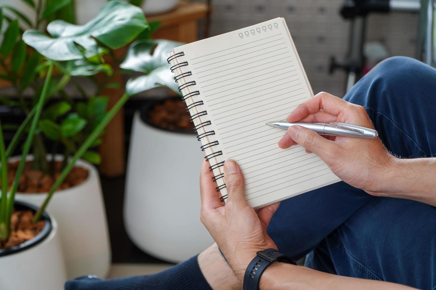 man sitting and resting using a pen to write a notebook.Business and education concept. photo