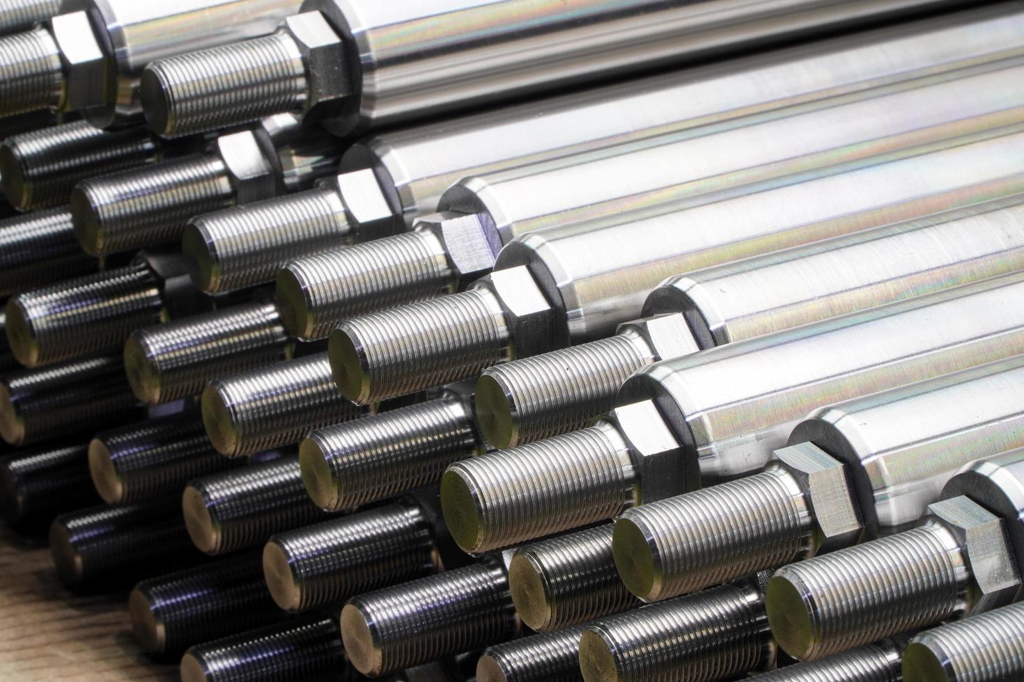 Shiny steel parts close-up background, long clean steel rods after fine cnc turning photo