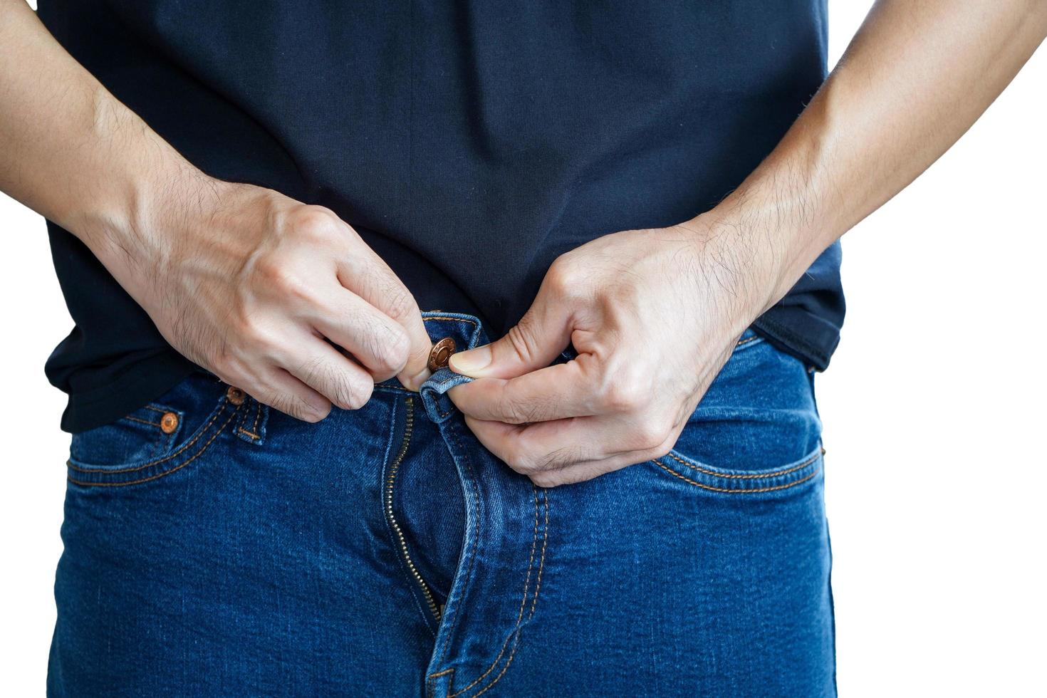Asian man trying to button up his pants. Man's hands. Close-up. Tighten. photo