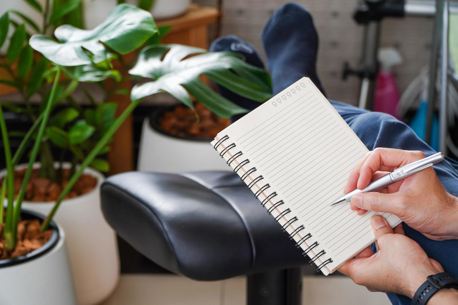 man sitting and resting using a pen to write a notebook.Business and education concept. photo