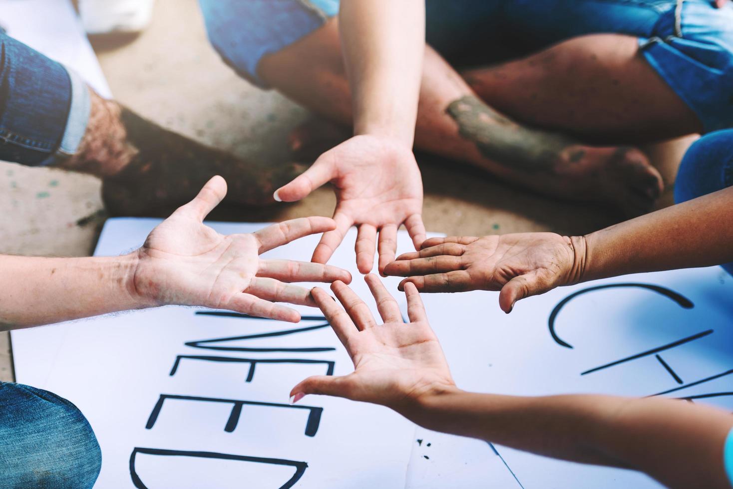 cerca de personas voluntarias que trabajan en equipo poniendo manos juntas, un montón de manos, unidad y trabajo en equipo en el día mundial del medio ambiente. foto