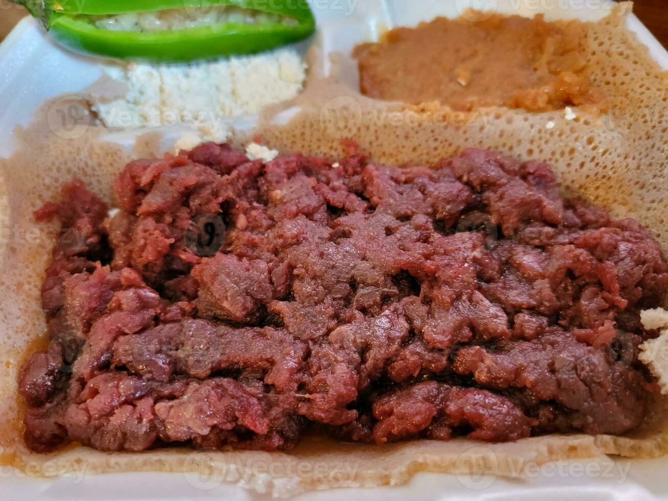 Ethiopian food kitfo raw beef and injera bread photo